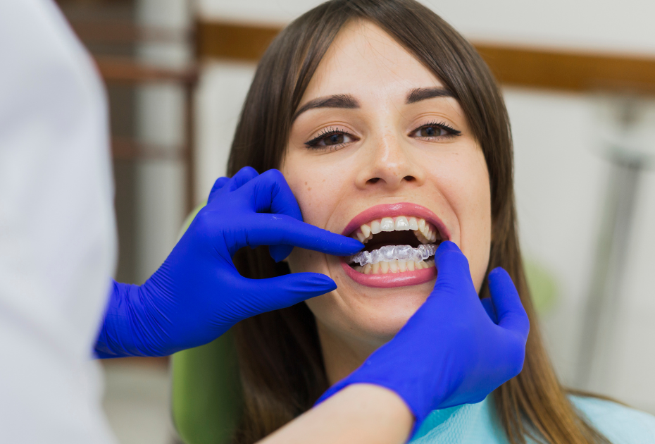 Orthodontist fitting clear aligners on a patient as part of a customized aligner treatment plan.
