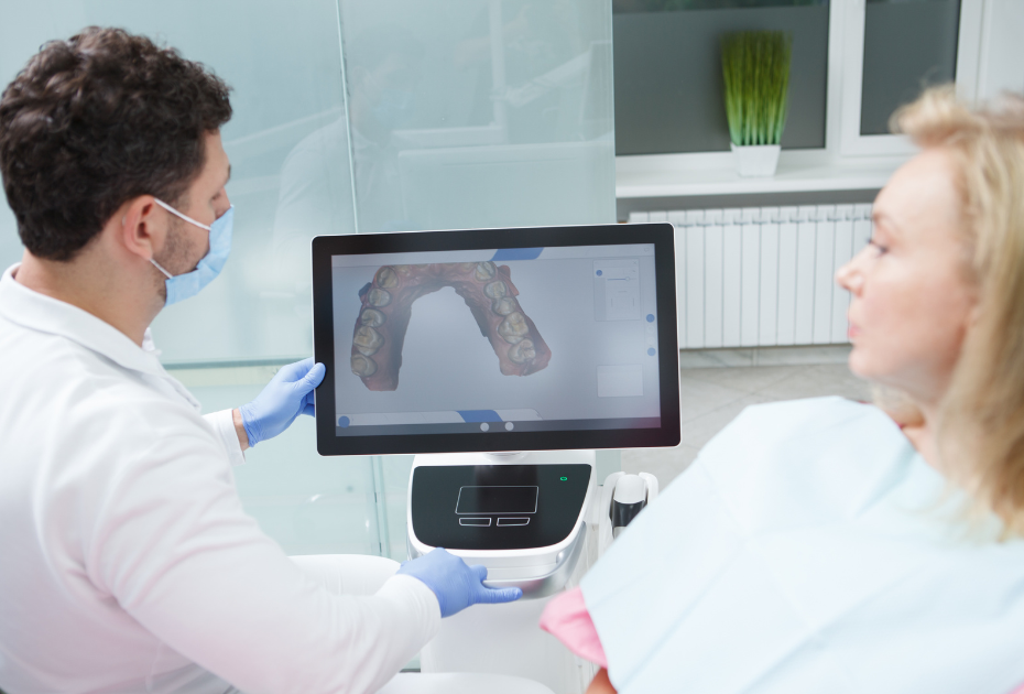 Dentist showing a patient a digital 3D scan during a clear aligner consultation.