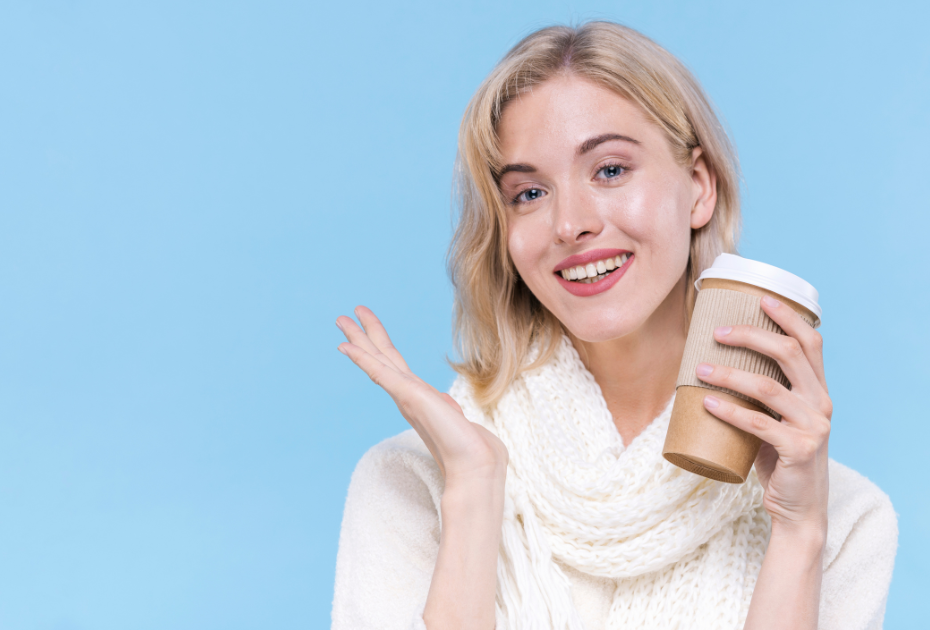 Woman holding a coffee cup smiling while wearing clear aligners.