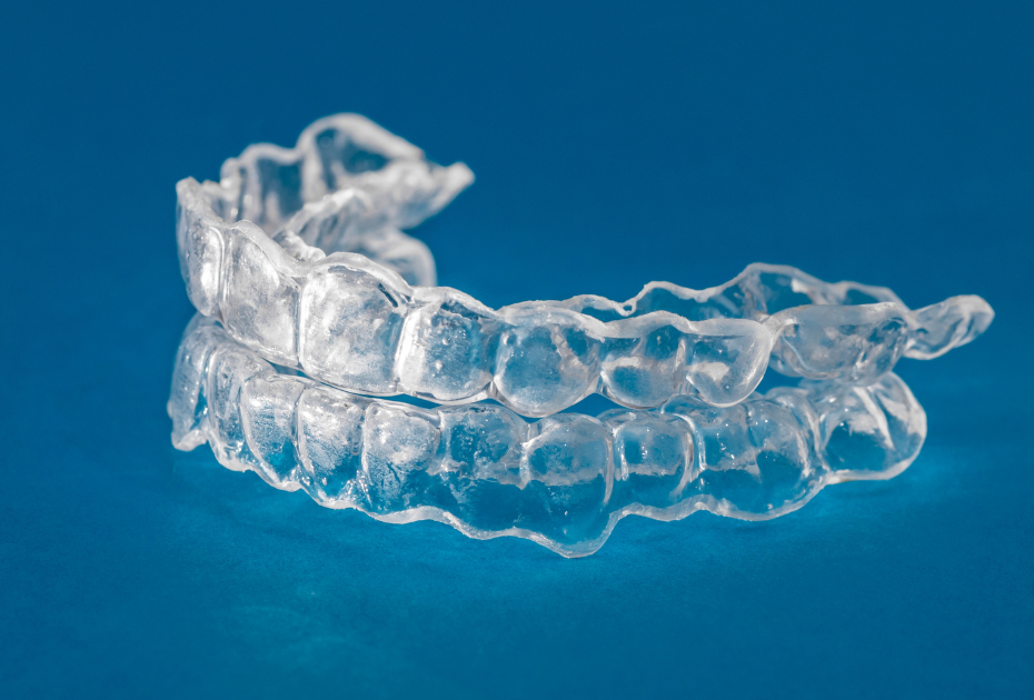 Clear dental aligners stacked together, showing transparent invisible braces used for teeth straightening.