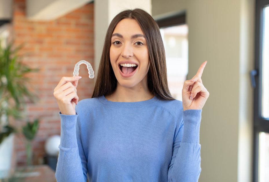 A young women holding clear aligners, starting her clear aligners journey online. 