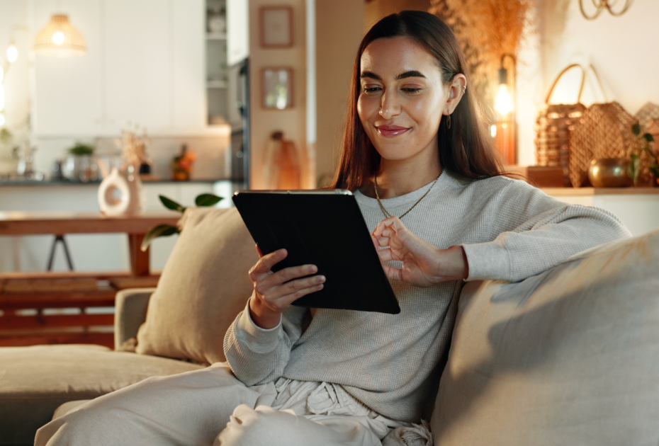 Woman using tablet at home to book clear aligner assessment online.