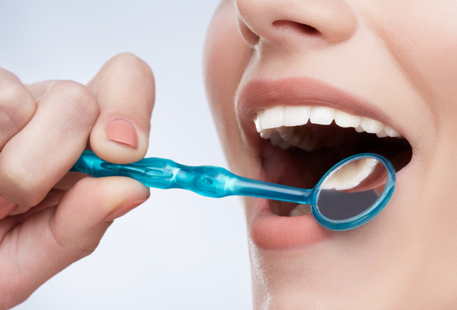 Close-up of healthy teeth being examined with dental mirror during oral hygiene check.