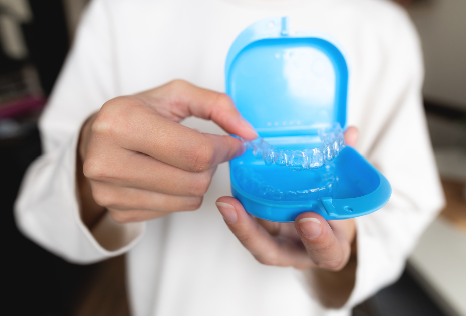 Clear aligner stored in a blue aligner case as part of a portable dental care kit