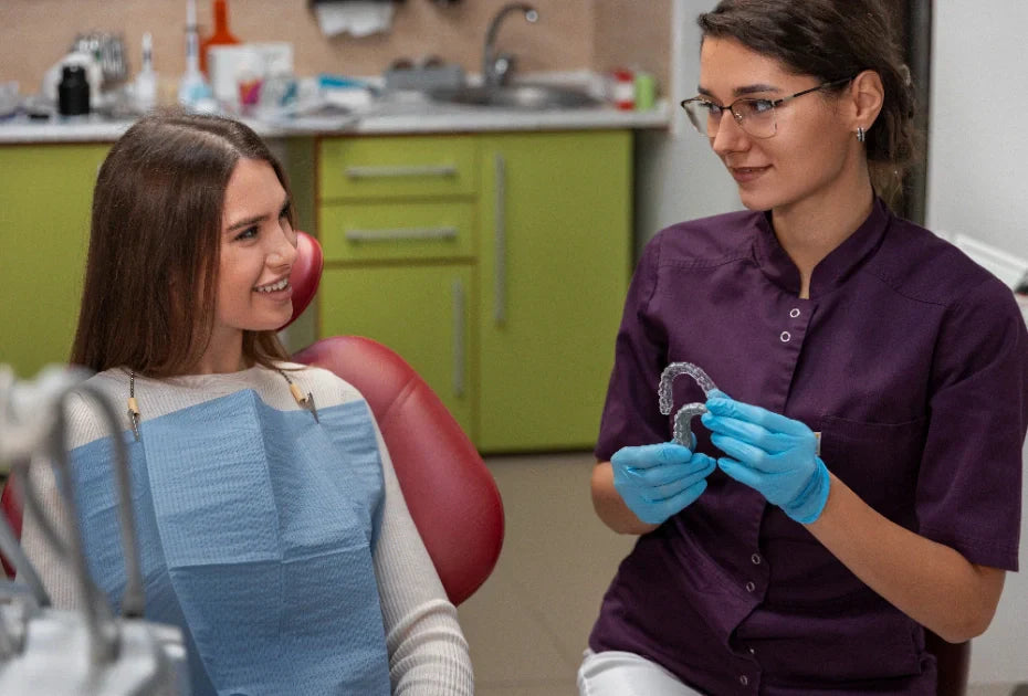  Dentist examining patient's retainer for cleanliness during regular dental visit